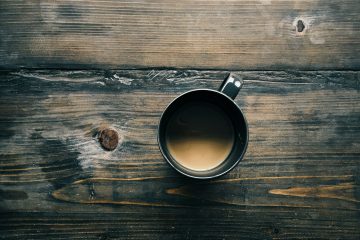 gray cup with brown liquid inside on top of table