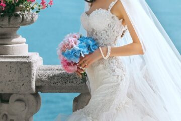 woman in wedding dress while holding flower during daytime
